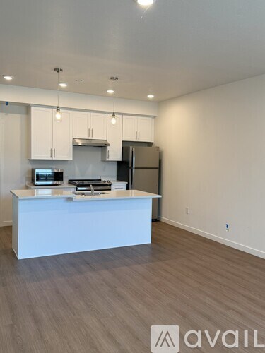 A kitchen with white cabinets and a white island with a countertop and sink.