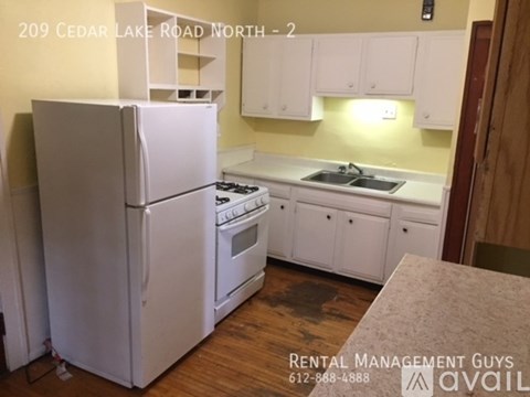 A kitchen with white appliances and cabinets is for rent.