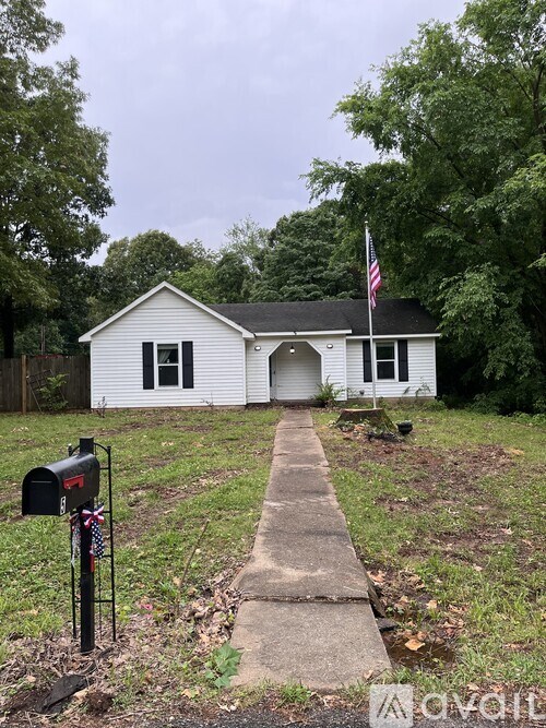 A white house with a mailbox and a flag on the front porch.