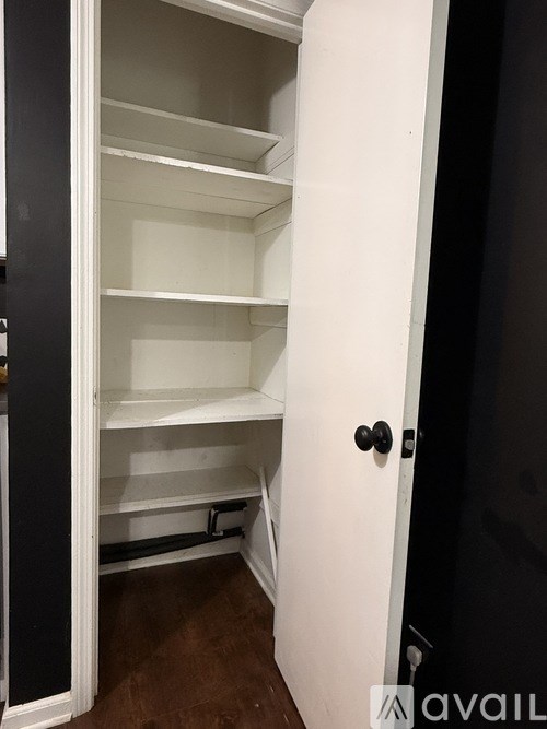 A room with a white door and two framed pictures on the wall.