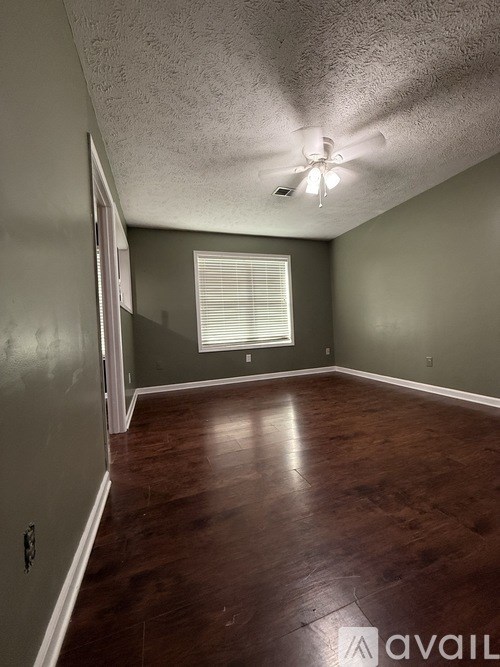 A room with a window and wooden floors.