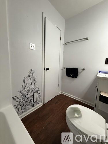A bathroom with a toilet, sink, and a door.