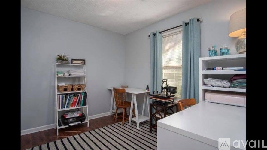 A room with a desk, chair, and bookshelf.