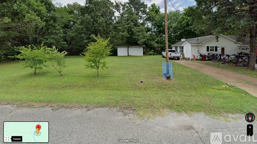 A Google Maps screenshot of a residential area with a house, trees, and a picnic table.