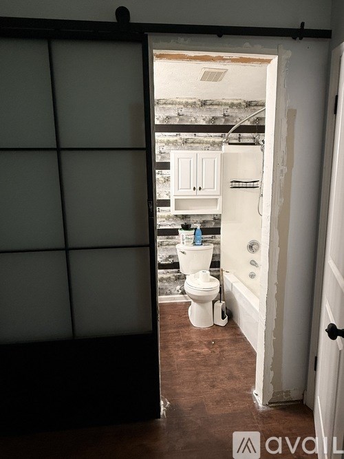 A bathroom with a toilet and a cabinet is shown.