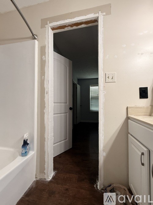 A bathroom with a white tub and a doorway leading to another room.