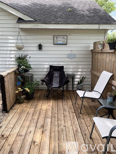 A wooden deck with a chair and a table.