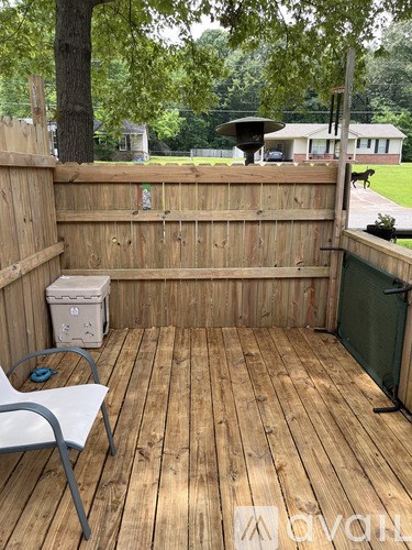 A wooden deck with a white chair and a trash can.
