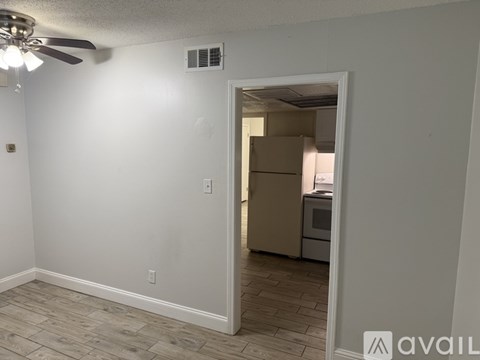 A room with a ceiling fan and a doorway leading to another room.