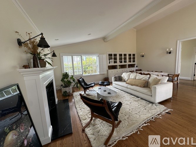 A living room with a white couch, a fireplace, and a television.