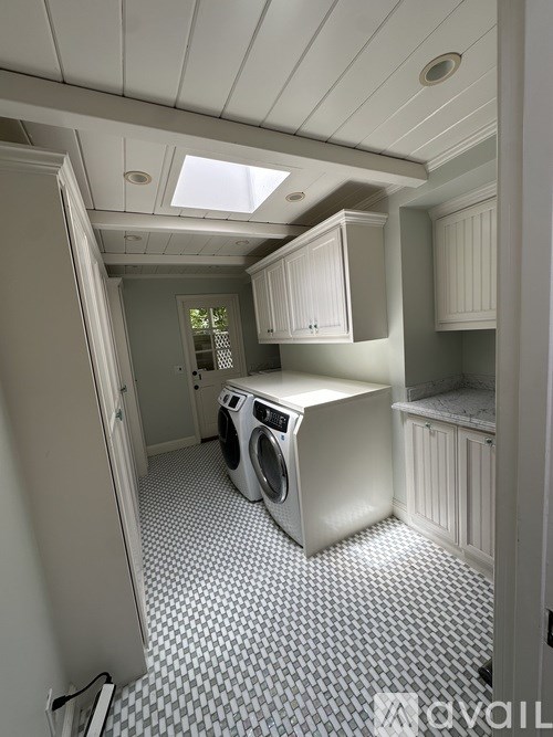 A small laundry room with a washing machine and a checkered floor.