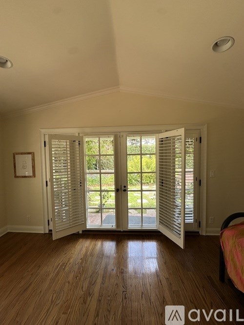 A room with a bed and a window with shutters.