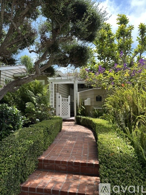 A white house with a tree in front of it.
