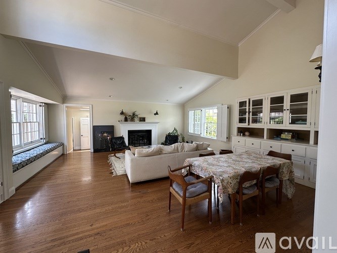 A spacious living room with a fireplace and a dining table set up.