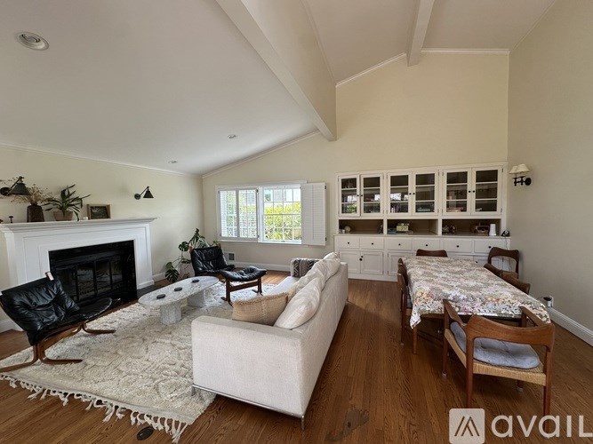 A living room with a fireplace, a couch, and a rug.