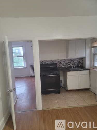 A kitchen with white cabinets and a black oven.