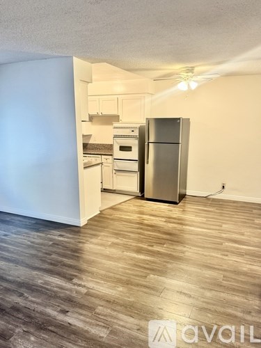 A kitchen with a refrigerator, oven, and stove.