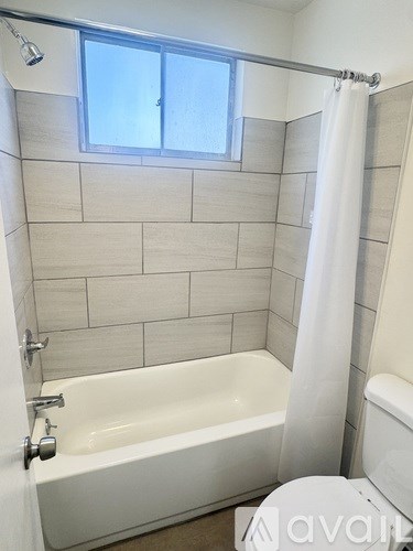 A white bathroom with a tub, toilet, and sink.