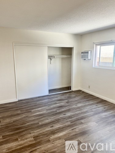 A room with wood flooring and a white door.