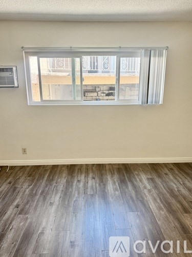 A room with a window and wooden flooring.