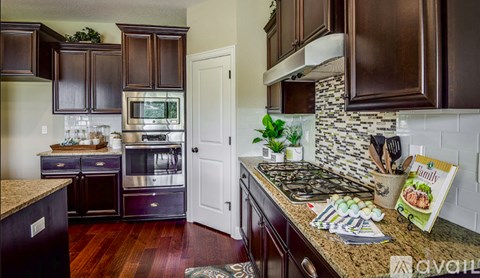 A kitchen with dark wood cabinets and a white door.