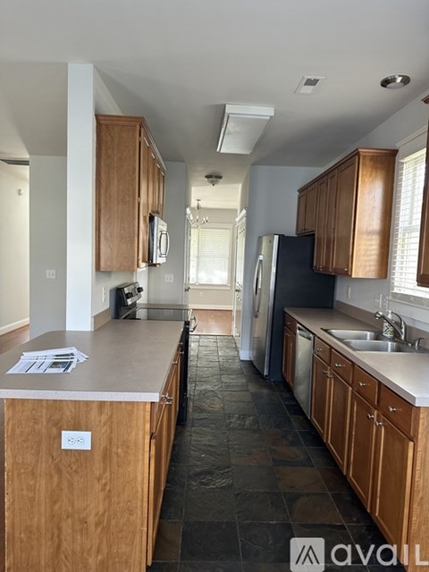 A kitchen with wooden cabinets and a black fridge.