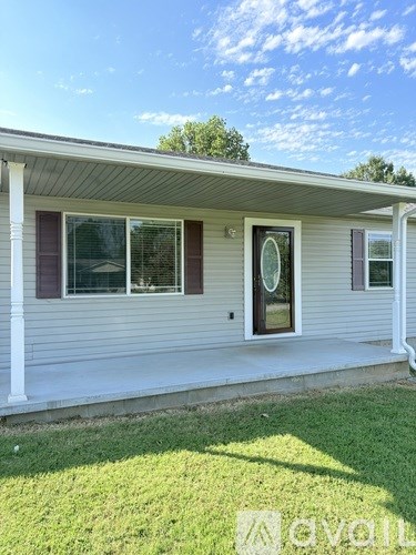 A house with a white porch and a grey siding exterior.