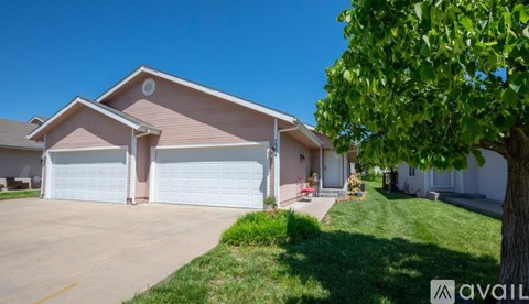 A house with a brown roof and white garage doors is for sale.