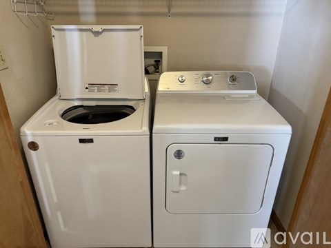 A white washing machine and dryer in a small room.