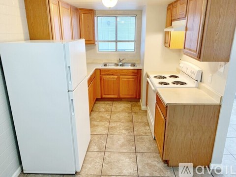 A kitchen with wooden cabinets and a white fridge.