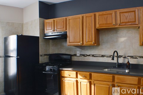 A kitchen with wooden cabinets and black appliances.