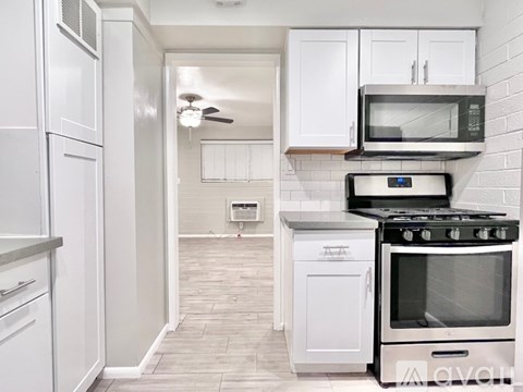 A kitchen with white cabinets and appliances.