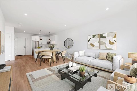 A modern living room with a dining area and kitchen in the background.