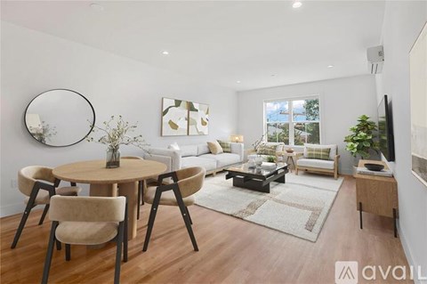 A modern living room with a round table and chairs, a sofa, and a television.