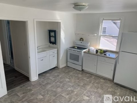 A kitchen with white appliances and cabinets.