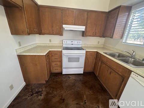A kitchen with brown cabinets and a white stove top oven.
