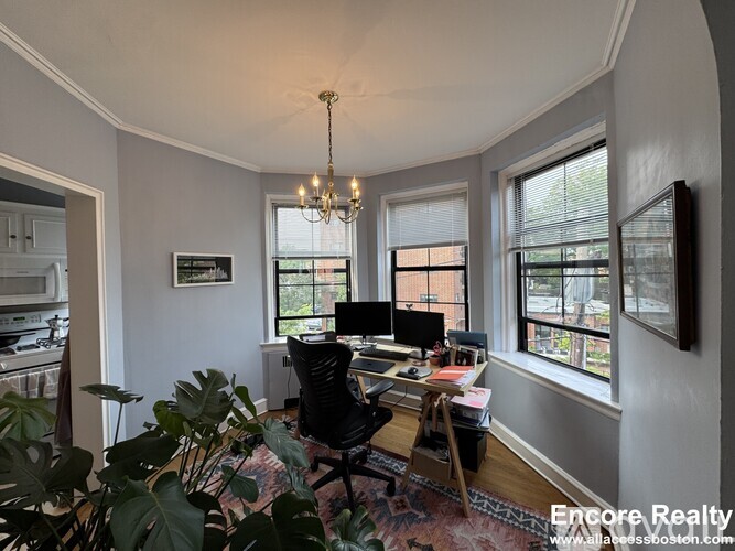 A well-lit room with a desk and a chair.