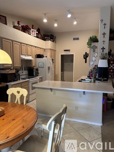 A kitchen with a table and chairs.