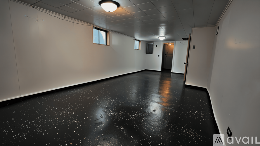 A spacious room with a black floor and white walls.