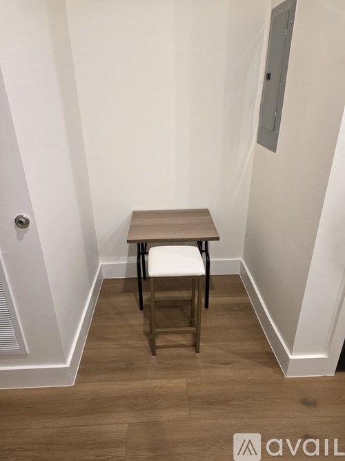 A small table with a chair in a corner of a room.