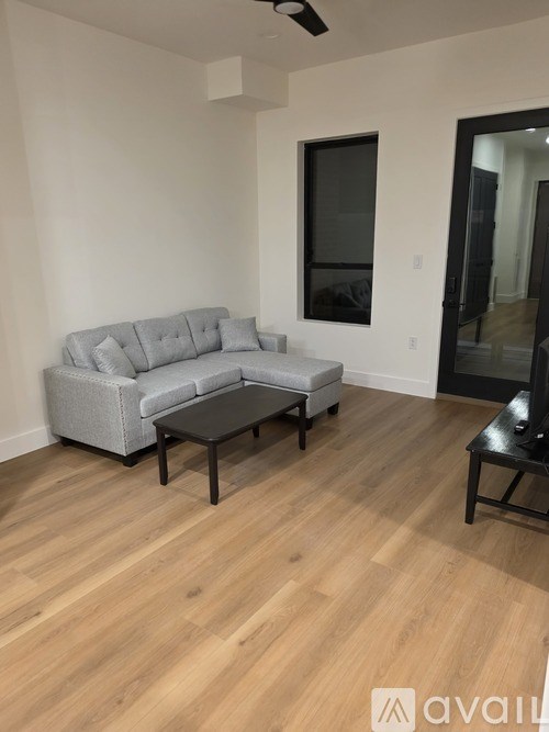 A living room with a grey couch and a black coffee table.