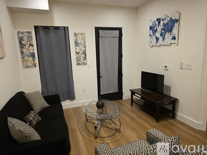 A kitchen with a table set for two and a couch.