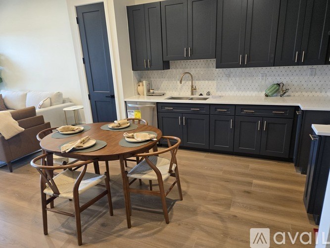 A kitchen with a table set for two and a couch.