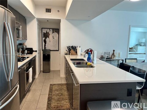 A kitchen with a white counter top and stainless steel appliances.