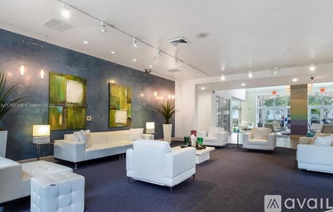 A spacious living room with white furniture and a large window.