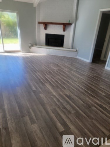 A room with a fireplace and wooden floors.