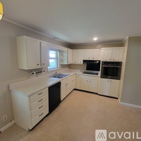 A kitchen with white cabinets and appliances.
