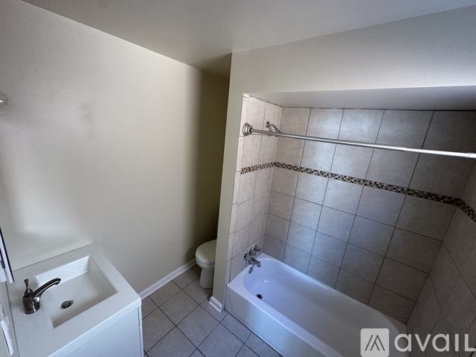 A bathroom with a white sink and a white bathtub.
