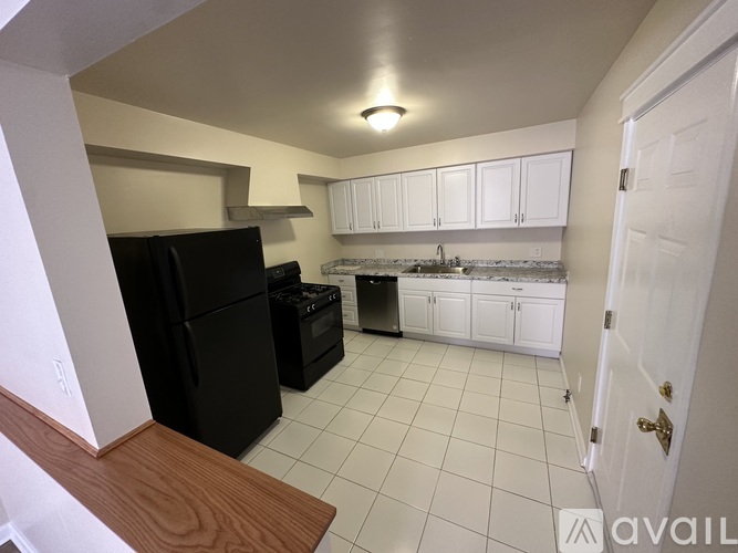 A kitchen with black appliances and white cabinets.
