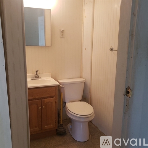 A white toilet sits next to a sink in a small bathroom.